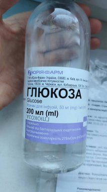 Dnipro, Ukrayna - 26 Nisan 2025 - Glikoz infüzyon şişesiyle yakın çekim yapılacak. Tıbbi tedavi, hastane bakımı, kan şekeri desteği, serum hidrasyonu. Dikey.