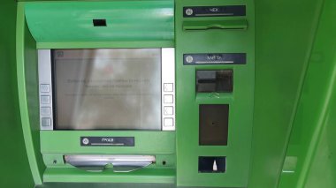 Dnipro, Ukrayna - 26 Nisan 2025 - Yeşil ATM kart yuvası ve mali işlemler için ekran. ulaşılabilir bankacılık, günlük hayatta teknoloji, nakit çekmenin kolaylığı.