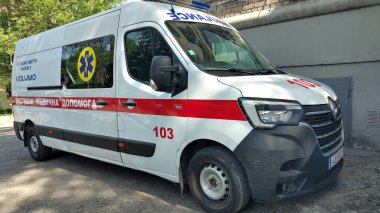 Dnipro, Ukrayna - 26 Nisan 2025 - Ambulans açık havada, binanın yakınında güneşli bir günde park etmiş. Acil servis kavramı, tıbbi müdahale, kamu güvenliği..