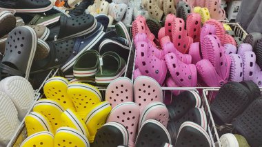 Dnipro, Ukrayna - 26 Nisan 2025 - Piyasada renkli lastik takunyalar sergileniyor. Crocs konsepti, moda ayakkabıları, rahat ayakkabılar, günlük tarz..