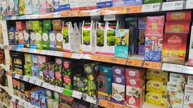 Dnipro, Ukrayna - 26 Nisan 2025 - Market çay reyonu çeşitli kaliteli çay markalarını renkli ambalajlarla sergiliyor. çay çeşitliliği, market alışverişi deneyimi, içecek seçimi çeşitliliği.