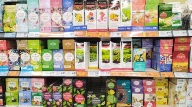 Dnipro, Ukrayna - 26 Nisan 2025 - Süpermarket rafında çeşitli aromalar ve markalar sergilenen renkli çay seçimi. içecek keşfi konsepti, aromatik seçenekler, market alışverişi macerası.