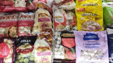 Dnipro, Ukrayna - 26 Nisan 2025 - bakkal vitrininde paketlenmiş hamur tatlısı ve pelmeni çeşitliliği. Uluslararası mutfak konsepti, gıda çeşitliliği, aşçılık keşfi.