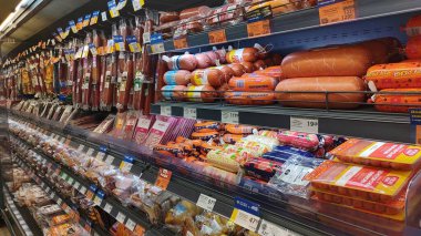 Dnipro, Ukrayna - 26 Nisan 2025 - Market koridorunda çeşitli paketlenmiş sosisler sergilenmektedir. Çeşitli gıda ürünleri için alışveriş, süpermarket seçimleri, uluslararası mutfak keşifleri.