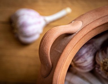 Still life with kitchen jar with garlic. Clay pot for garlic. Kitchen utensil. Clay pot, handmade.