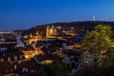 Prag - Prag Kalesi 'nden gece görüşü. Aziz Niklas Kilisesi ve Petn Kulesi manzarası.