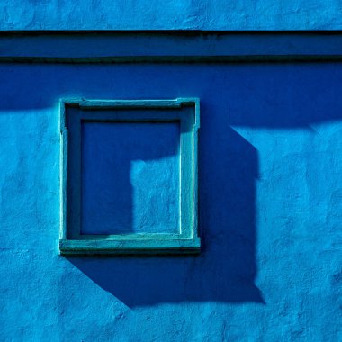 Duvardaki çerçeve. Pencere. Şehrin tarihi bölgesindeki bir evin detayları. Mavi.