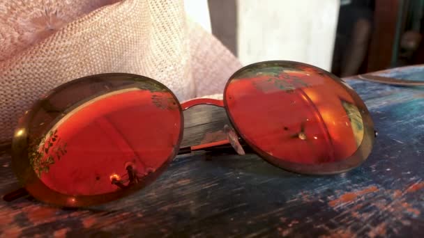 Sonnenbrillen Großaufnahme Auf Dem Tisch Spiegelung Den Okularen Eines Deckenventilators — Stockvideo