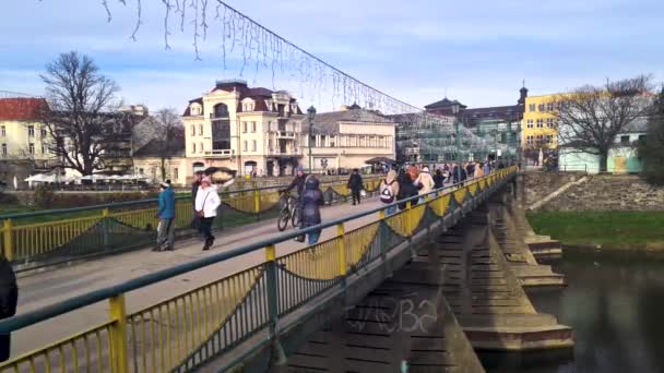 ウジホロド ウクライナ 12月2022 人々はウジロド川を渡ってウジロドの古代の有名な歩道橋を歩く — ストック動画