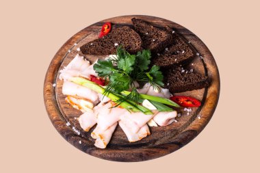 Lard slice black bread and greens on a wooden board on a isolated background top view.
