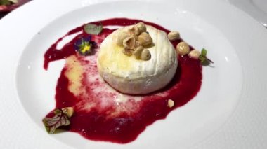 Kızılcık soslu kızarmış camembert peyniri, bal ve fındıklı, büyük bir tabakta. Yüksek kalite 4k görüntü