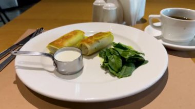 Ekşi kremalı krep tabakta ıspanak. Sağlıklı spor kahvaltısı. Yüksek kalite 4k görüntü