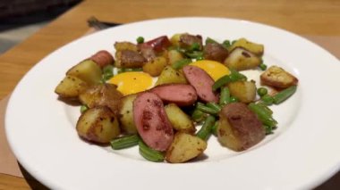 Amerikan kahvaltısı kızarmış yumurta ve bezelye yeşil fasulye ve sosisli patates. Yüksek kalite 4k görüntü