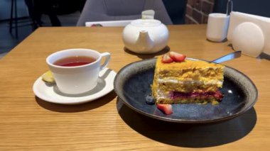 Modern bir restoranda vişne reçeli katmanlı mascarpone kremasına batırılmış bal pastası. Yüksek kalite 4k görüntü