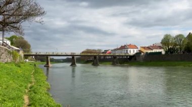 Güzel bir bahar gününde Uzhhorod yaya köprüsü. Uzhhorod, Transcarpathia 'daki Uzh nehri üzerindeki köprü. Yüksek kalite 4k görüntü