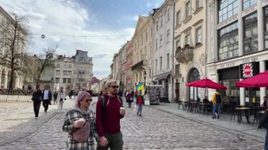 Lviv, Ukrayna - Mayıs 2023: Eski Lviv kasabasındaki Pazar Meydanı mimarisinde yürüyen insanlar. Yüksek kalite 4k görüntü