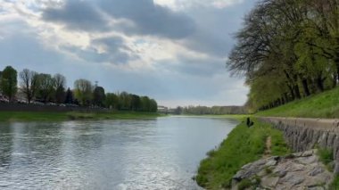 Cloudy landscape of the embankment of the river Uzh in Uzhhorod in the spring at the golden hour.