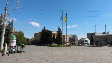 Ukrayna, Rivne - Mayıs 2023: Taras Shevchenko anıtıyla Rivne kentinin merkez meydanı, bayraklar sallıyor ve yürüyen insanlar. Yüksek kalite 4k görüntü