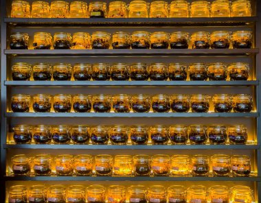 Rafta duran cam dekoratif kavanozlarda farklı aromalı nargile tütünü. Yüksek kalite fotoğraf
