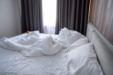 Buruşuk Çarşaflı ve Doğal Işıklı Yapılmamış Otel Odası.