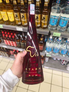 Grand Bay, Mauritius - 29 Ocak 2025: Starr Rum Şişesi Dukes ve Yedi Deniz İçkisi Arka planda. Yüksek kalite fotoğraf