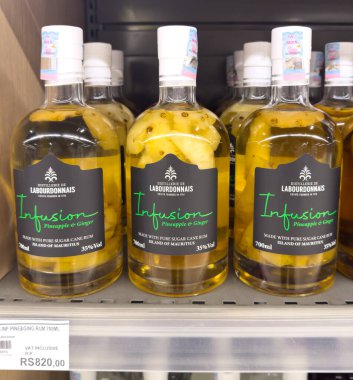 Grand Bay, Mauritius - 29 Ocak 2025: Labourdonnais Enfüzyon Ananas ve Ginger rom şişelerinin yakın çekimi perakende rafında sergileniyor.