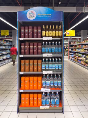 Grand Bay, Mauritius - 29 Ocak 2025: Bir süpermarket koridorunda New Grove ve ve Seven Seas rom markalarının yer aldığı tanıtım standı.