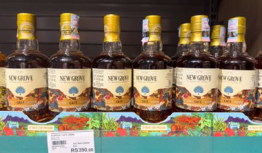 Grand Bay, Mauritius - 29 Ocak 2025 Mauritius Adası 'ndan New Grove Cafe Rum Likörü şişeleriyle dolu perakende raf.