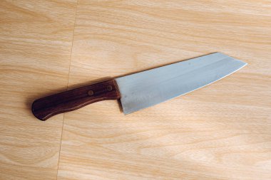 Ahşap arka planı olan bir mutfak bıçağı..