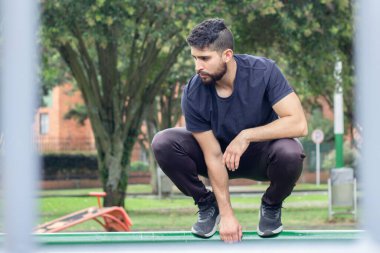 Genç adam şehir parkında antrenman yapıyor ve parkçılık yapıyor.