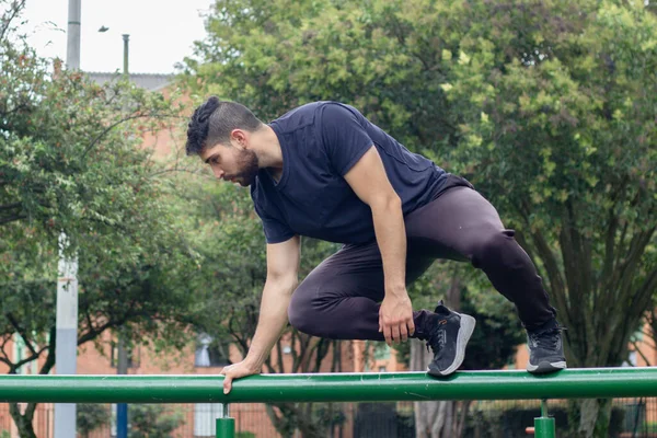 Genç adam şehir parkında antrenman yapıyor ve parkçılık yapıyor.