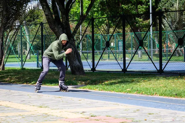 在城市的一个公园里 一个年轻人在溜冰鞋上滑冰 — 图库照片