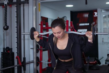 Güzel genç bir kadın spor salonunda bacak egzersizi yapıyor.