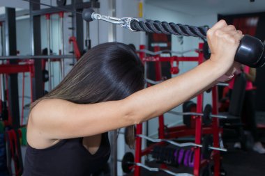 Sportif bir kadın spor salonunda kol ve omuz kasları için egzersiz yapıyor. Spor salonunda spor yapmak.