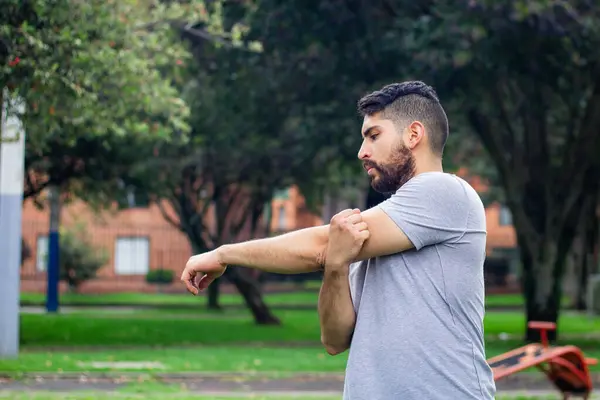 young fitness man doing stretching to do physical training in a park in the city