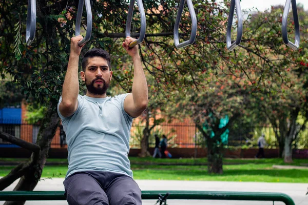 young man doing arm exercise in a park in the city
