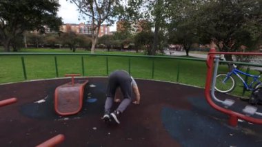 Genç adam şehir parkında rutin bir egzersiz yapıyor.