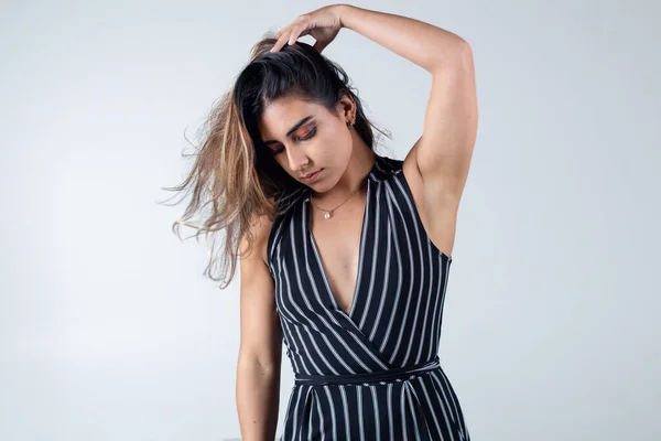 Renkli arka planda çizgili takım elbise giyen modern moda sarışın manken fotoğraf stüdyosunda izole edilmiş.