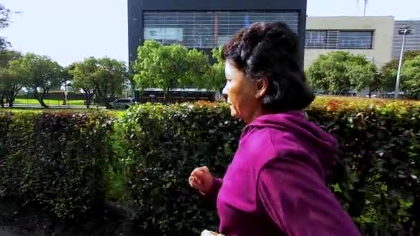 城市里的一位老年妇女早上在公园里跑步 — 图库视频影像