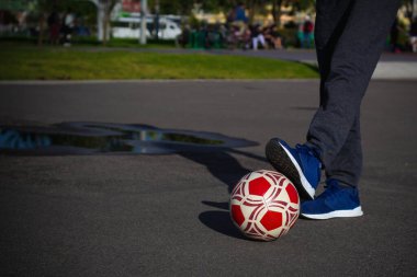Parktaki bir sahada futbol topuyla kıdemli emekli adam.