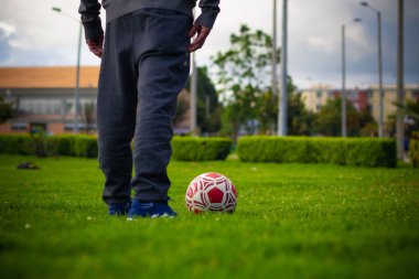 Parkta futbol topu taşıyan emekli son sınıf öğrencisi.