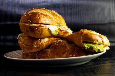 Kahvaltı tabağında peynirli salata ve mayonez ve açık ekmekle birlikte karanlık arka planda sandviçin fotoğrafçılığı.