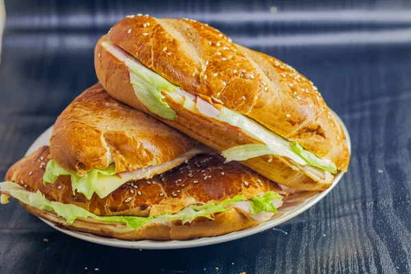 Kahvaltı tabağında peynirli salata ve mayonez ve açık ekmekle birlikte karanlık arka planda sandviçin fotoğrafçılığı.
