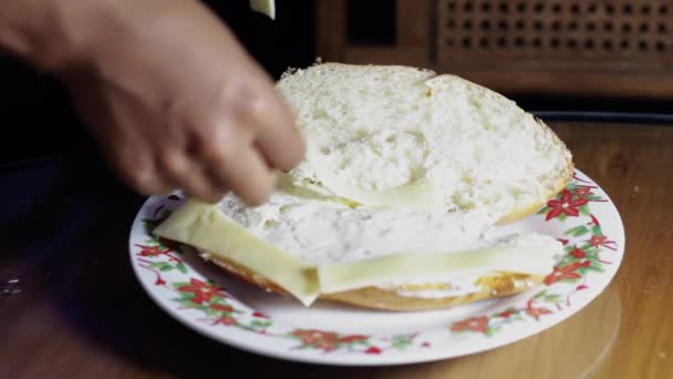 女人的手在面包上涂黄油 用小刀在厨房桌子上的盘子里准备沙巫婆 — 图库视频影像