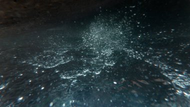 Güneş ışığı parıldıyor, yüzey ve mavi okyanusun altında, deniz dalgaları, yaz mevsiminde su altında temiz sular.