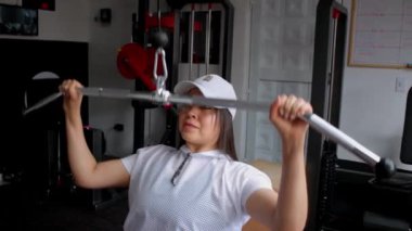 Spor salonunda spor yaparken spor makinesinde kol egzersizi yapan spor sporcusu bir kadın.