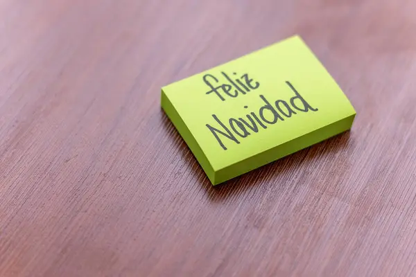 Ahşap masa arkasında yapışkan bir not. Yazılı not: Mutlu Noeller.