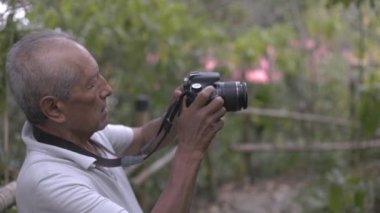 Dağdaki kıdemli doğa fotoğrafçısı - profesyonel film yapımcısı ormanda doğa videosu kaydediyor