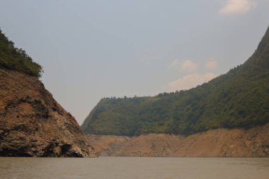 Kayalık dağların ortasında bitkilerle dolu bir su deposu.