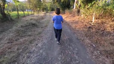 Yazın dağlarda ormanda yürüyüş yapan olgun, beyaz bir kadın. Macerasının tadını çıkarıyor. Turizm konsepti.